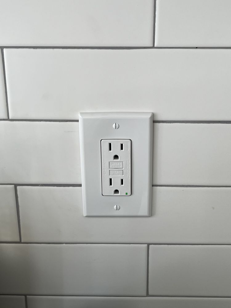 Electrician mid-repair inside a Garland home with the panel open